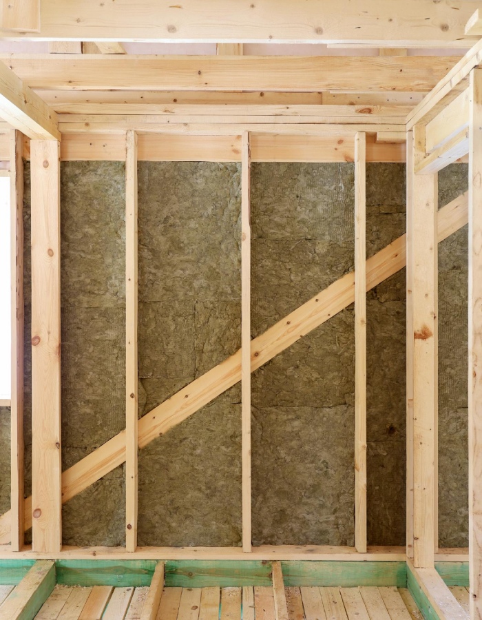 Pose de panneaux isolants entre montants d’une ossature en bois